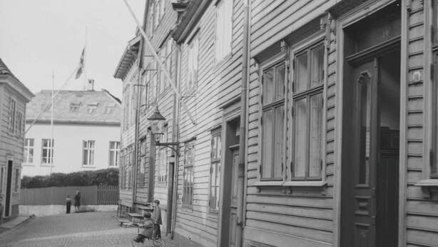 A cobblestone street lined with traditional wooden buildings, featuring large windows and a bicycle parked outside. - 500m to Bryggen • Renovated 2025 • Bathtub Bliss! (Bergen)