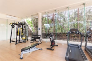 A gym with various exercise equipment, including a treadmill, stationary bike, and weight machines. - Cozy 1-bedroom condo in serene Tulum with AC, pool, gym access and bikes (Tulum)