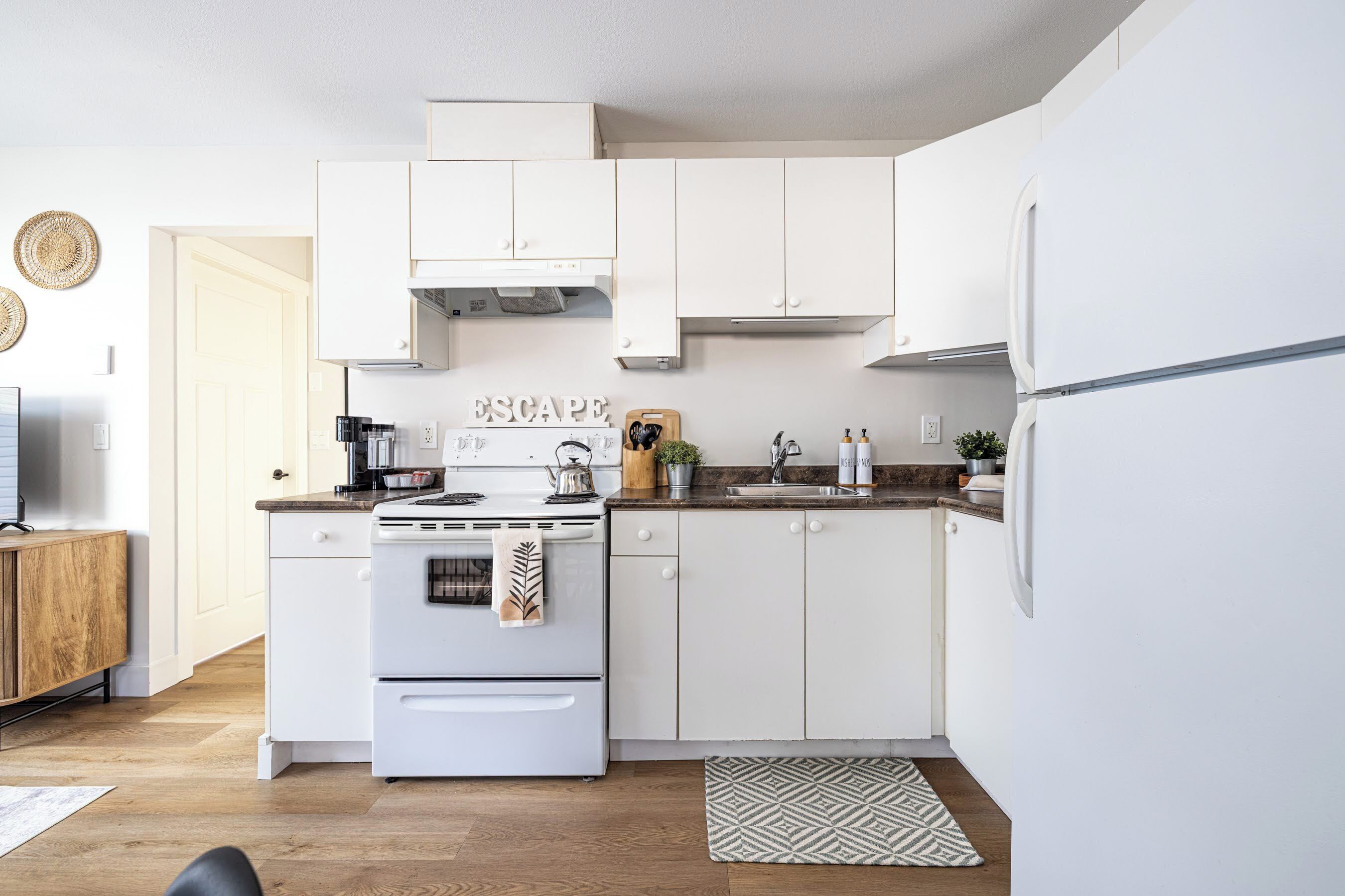 Una cocina moderna con armarios blancos, una estufa y un refrigerador.