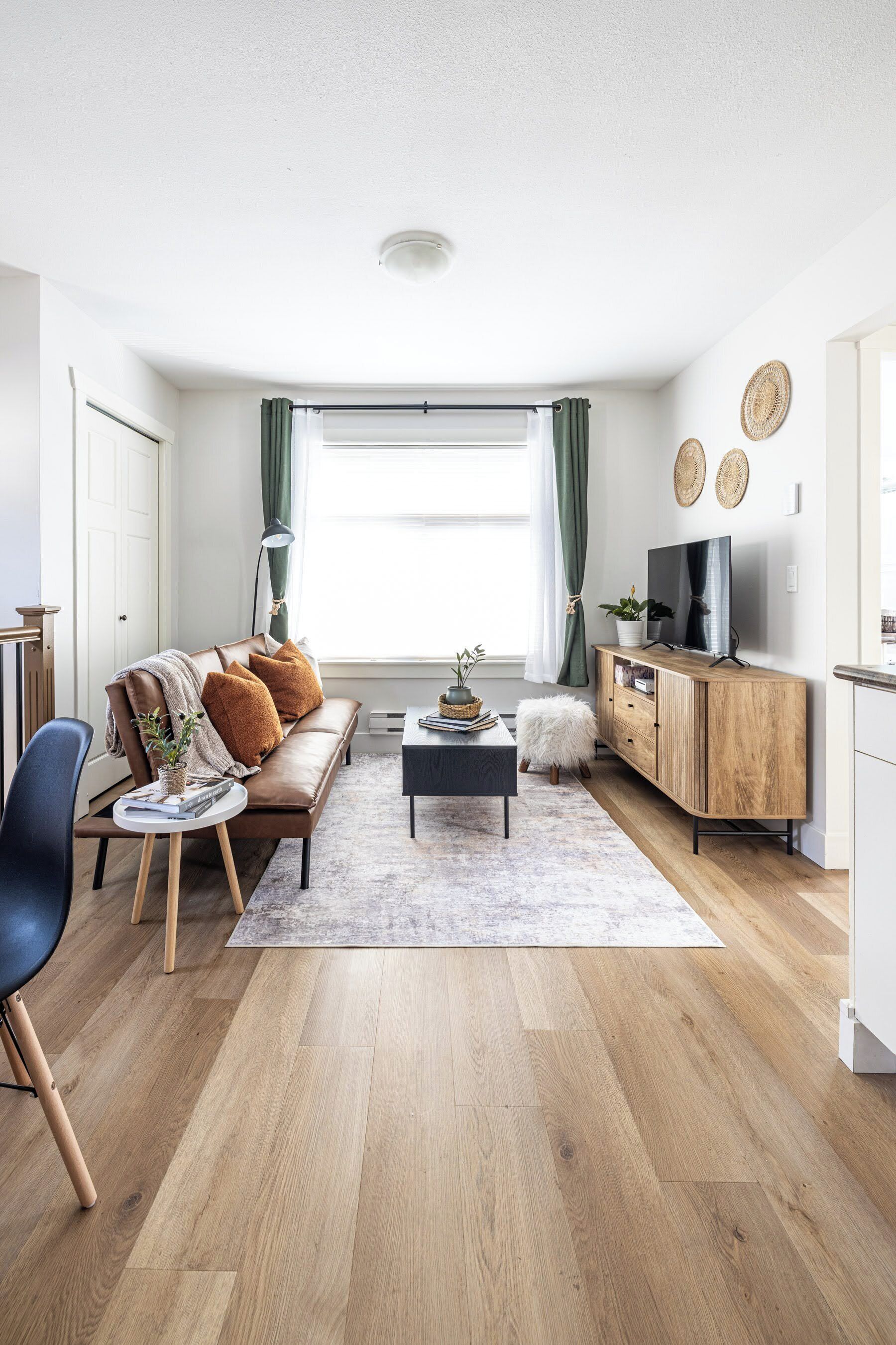 Una sala de estar moderna con sofá, mesa de centro y televisor.