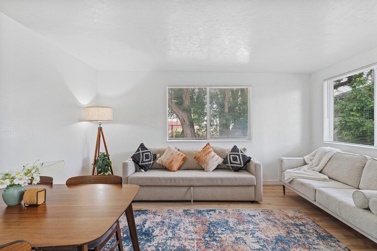 A living room with a sofa, a dining table, and a lamp.