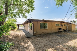 A single-story mobile home with a front porch, a satellite dish, and a small attached garage.