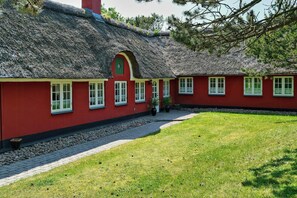 A traditional red building with a thatched roof and multiple windows. - Nature retreat with sauna in Ho (Blåvand)