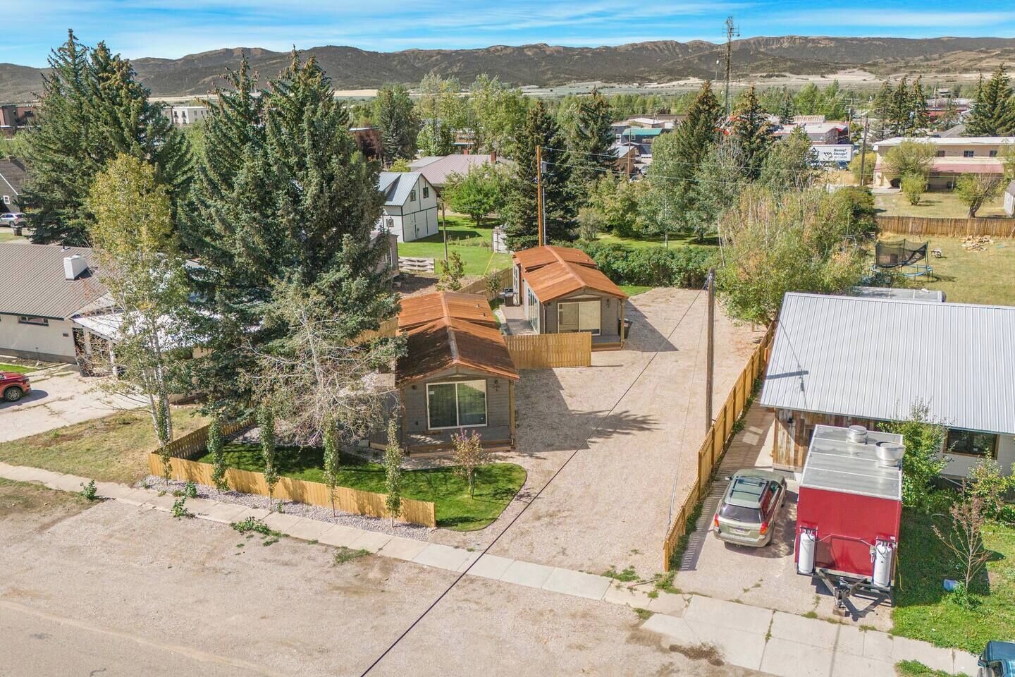Ett bostadsområde med hus, en klar himmel och avlägsna berg.