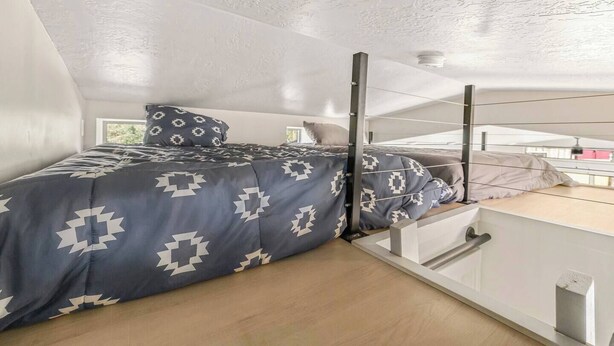 Un dormitorio pequeño con una cama litera, una ventana y vistas al exterior.