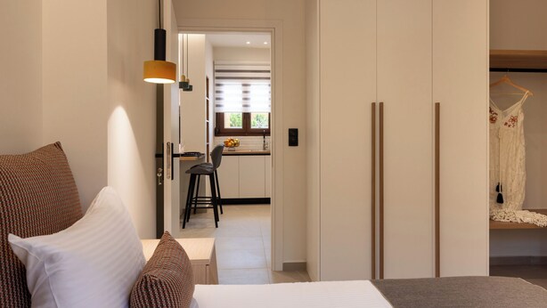 Hotellihuone, jossa on sänky, työpöytä ja vaatekaappi.