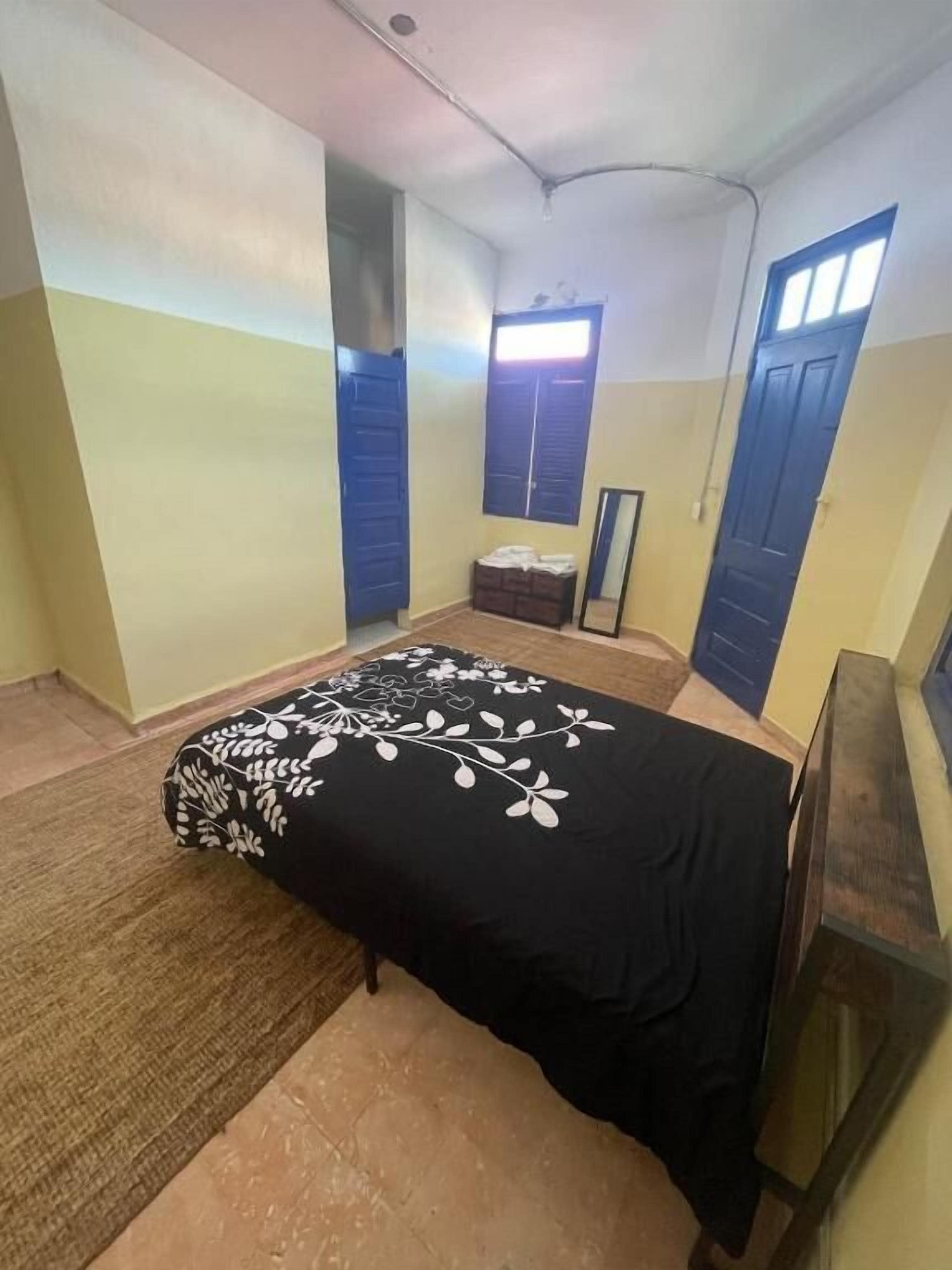 A room with a bed, a small table, and a wardrobe.