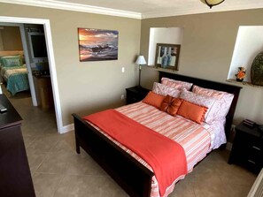 A bedroom with a bed, a nightstand, a lamp, and a painting on the wall. - 2BR/2BA Beach Condo- Full Kitchen-sleeps 4 (Daytona Beach)