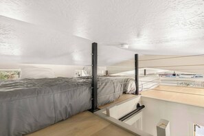 A modern bedroom with a bed, a window, and a view of the outside. - Sleeps 12! Teton Bungalows! 2 Cabins! (Driggs)