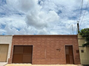 A building with two large garage doors, a number '123' on the wall, and a clear sky with clouds.