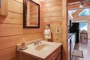 A wooden interior with a sink, mirror, and towel rack. - Moose Cabin /Hot Tub - A Bridge to Mountain Bliss (South Fork)