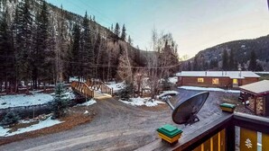 A cabin with a satellite dish, a wooden deck, and a view of a forested area. - Gressoney Family Retreat | Pond & Hot Tub (South Fork)