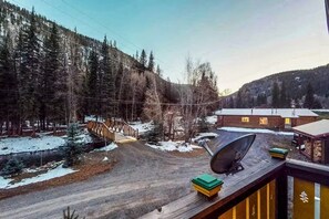 A cabin with a satellite dish, a wooden deck, and a view of a forested area. - Gressoney Family Retreat | Pond & Hot Tub (South Fork)