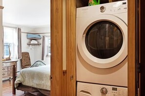 A room with a bed, a wooden wardrobe, and a washing machine. - Gressoney Family Retreat | Pond & Hot Tub (South Fork)
