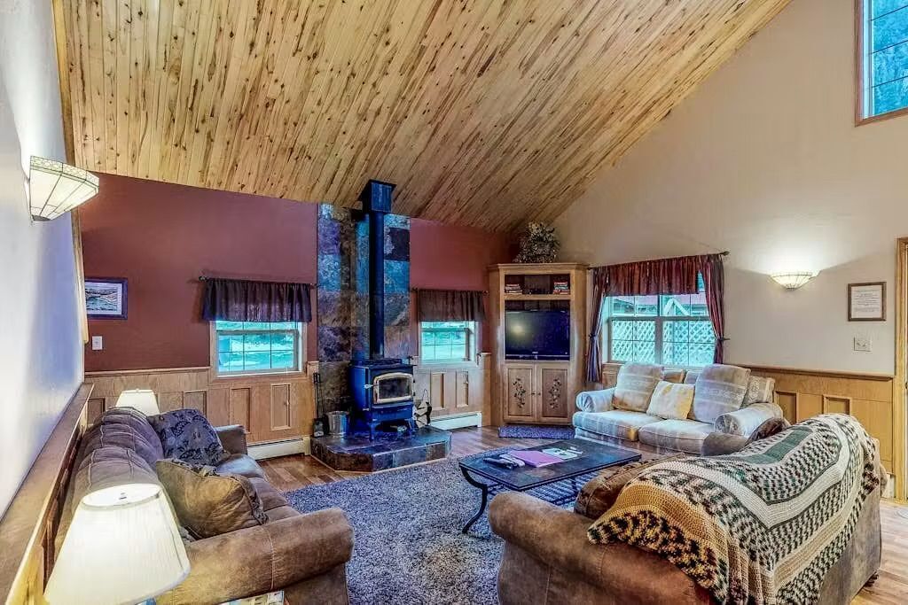 A cozy living room with a fireplace, sofas, and a television.