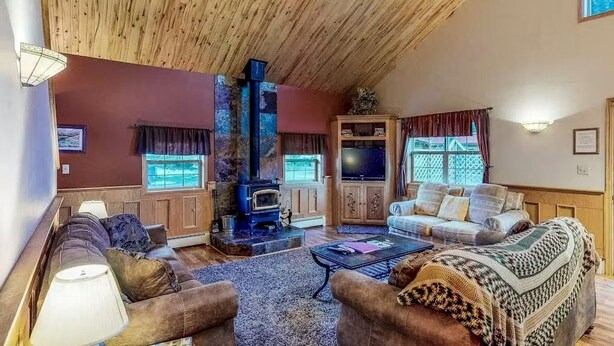 A cozy living room with a fireplace, sofas, and a television. - Gressoney Family Retreat | Pond & Hot Tub (South Fork)