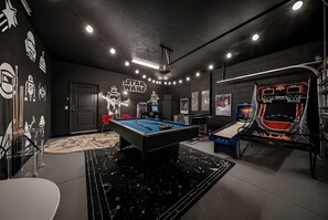 A room with a pool table, Star Wars decor, and a basketball arcade. - Hogwarts & Star Wars Themed Rooms, Pool, Game Room (Davenport)