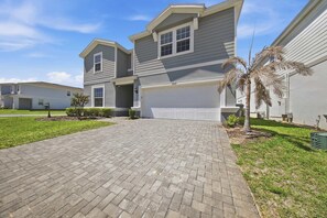 A two-story residential building with a paved driveway and a garage. - Hogwarts & Star Wars Themed Rooms, Pool, Game Room (Davenport)