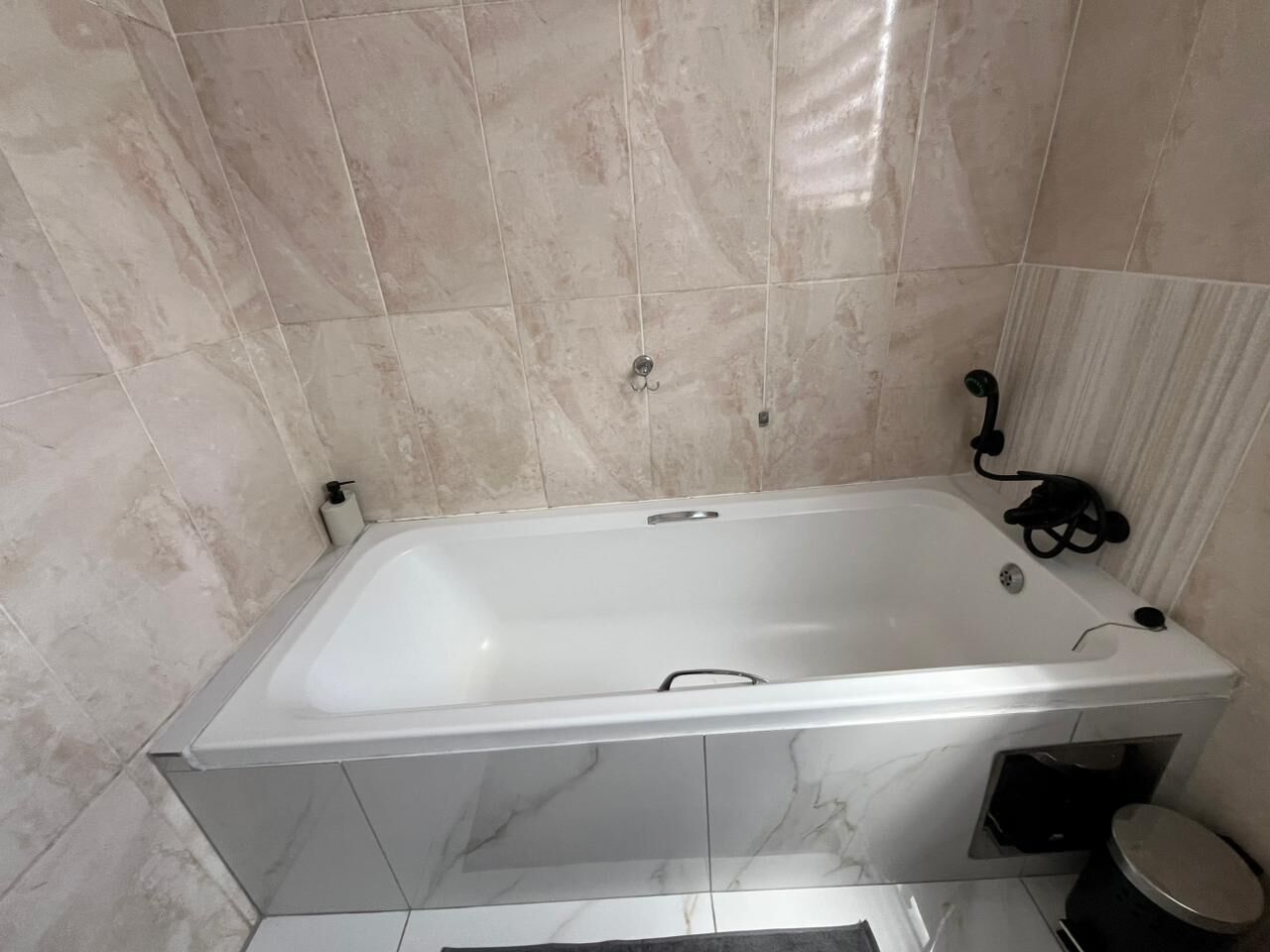 Une salle de bain avec une baignoire blanche, des toilettes et un espace douche.