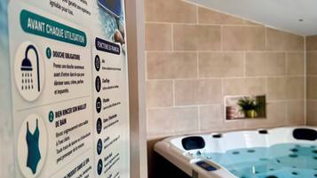 A spa area with a hot tub and informational signage detailing usage instructions.