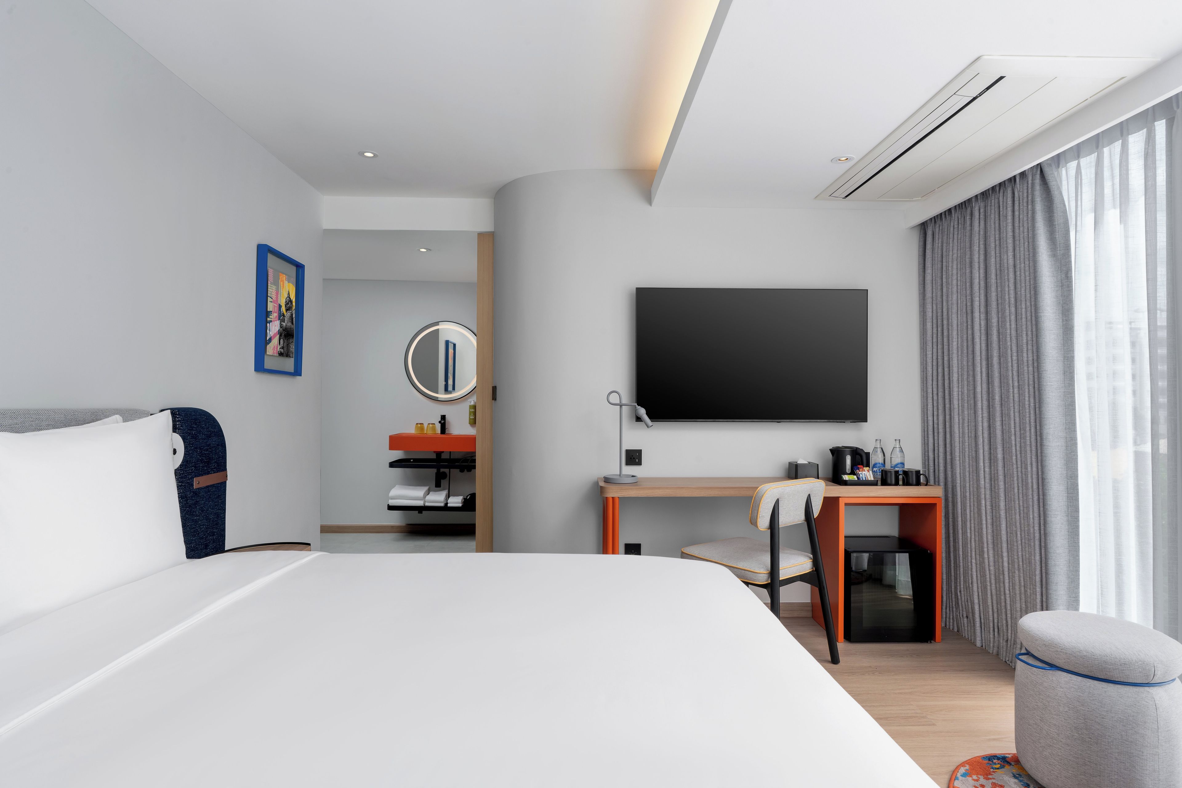 Une chambre d’hôtel avec un lit, un bureau, une télévision et une salle de bain.