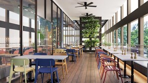 Un espace de restauration intérieur moderne, doté de murs en verre, de planchers en bois et offrant une variété de types de sièges.