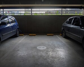 Eine Parkgarage mit zwei Autos, Betonboden und der Nummer 24.
