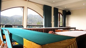 Une salle de conférence dotée d’une longue table, de chaises et offrant une vue sur un paysage montagneux grâce à de grandes fenêtres.