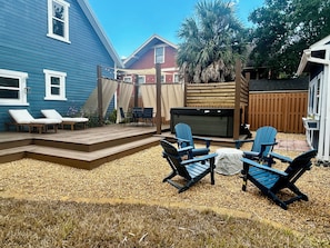 Un jardin avec une terrasse en bois, du mobilier d’extérieur et un espace salon abrité.