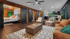 Una sala de estar moderna con sofá, mesa de centro y cama con puerta corrediza.