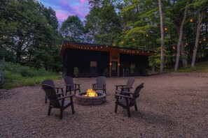 A cabin with a fire pit and outdoor seating. - The Lodge at Rivers Edge Retreat | Hot tub + Pickleball (Malvern)