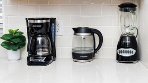 Eine Küchenarbeitsfläche mit Kaffeemaschine, Wasserkocher und Mixer.