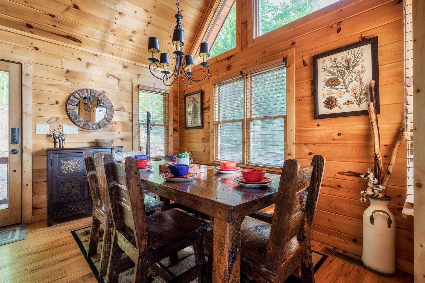 Un interior de madera con una mesa de comedor dispuesta para cuatro personas, rodeada de sillas de madera.