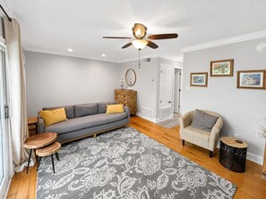A living room with a sofa, armchair, round coffee table, and a patterned rug.
