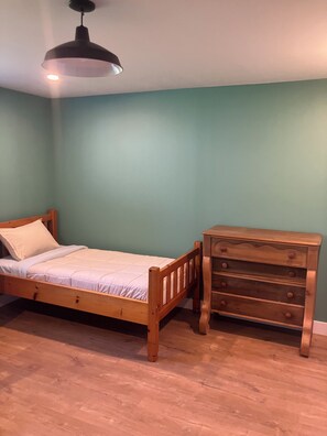 A bedroom with a wooden bed, a dresser, and a ceiling light fixture. - Georgetown Ranch Rental - Great For Families & Golfers! (Georgetown)