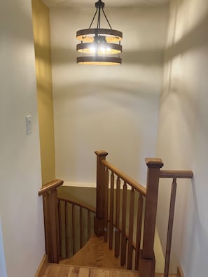 A wooden staircase with a modern light fixture above. - Georgetown Ranch Rental - Great For Families & Golfers! (Georgetown)