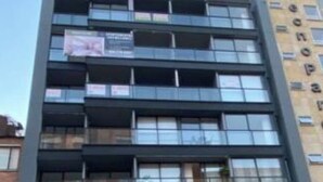 Ein mehrstöckiges Gebäude mit moderner Architektur, mit Balkonen und großen Fenstern.