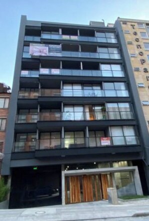 A multi-story building with a modern architectural design, featuring balconies and large windows. - Modern apartment with a view of central Chapinero (Bogotá)