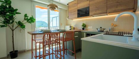 Una cucina moderna con isola centrale, mobili in legno e vista attraverso un'ampia finestra.