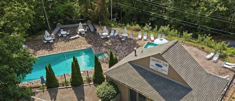 A pool area with lounge chairs and a sign for the Owners Club.