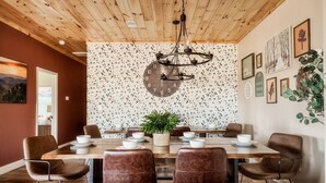 A dining area with a wooden ceiling, a large clock, and a terrazzo wall. - Private Pool • Smoky Mountain Views • Game Room (Gatlinburg)