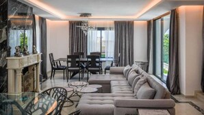 A modern living room with a sectional sofa, dining area, and a fireplace. - Calle las camelias (Marbella)