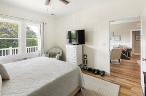 Een slaapkamer met een bed, een televisie op een dressoir, een stoel en uitzicht op de omgeving.