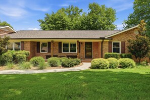 A two-story brick house with a front porch, a covered patio, and a well-maintained lawn. - 4Br Lux Stay w/Pool & Game Room - Sleeps 10 (Concord)