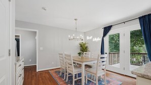 A dining area with a table, chairs, a chandelier, and a view of the outdoors through a door. - 4Br Lux Stay w/Pool & Game Room - Sleeps 10 (Concord)
