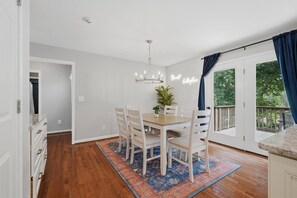 A dining area with a table, chairs, a chandelier, and a view of the outdoors through a door. - 4Br Lux Stay w/Pool & Game Room - Sleeps 10 (Concord)