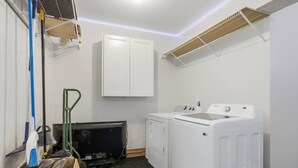 A laundry room with a washing machine, dryer, and a cabinet. - 4Br Lux Stay w/Pool & Game Room - Sleeps 10 (Concord)