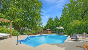 A rectangular swimming pool with a metal ladder, surrounded by a concrete deck. There are lounge chairs and a hammock on the deck. - 4Br Lux Stay w/Pool & Game Room - Sleeps 10 (Concord)