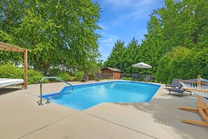 A rectangular swimming pool with a metal ladder, surrounded by a concrete deck. There are lounge chairs and a hammock on the deck. - 4Br Lux Stay w/Pool & Game Room - Sleeps 10 (Concord)