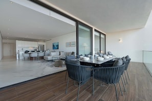 Eine moderne Küche mit Essbereich, großen Fenstern und Blick ins Freie.